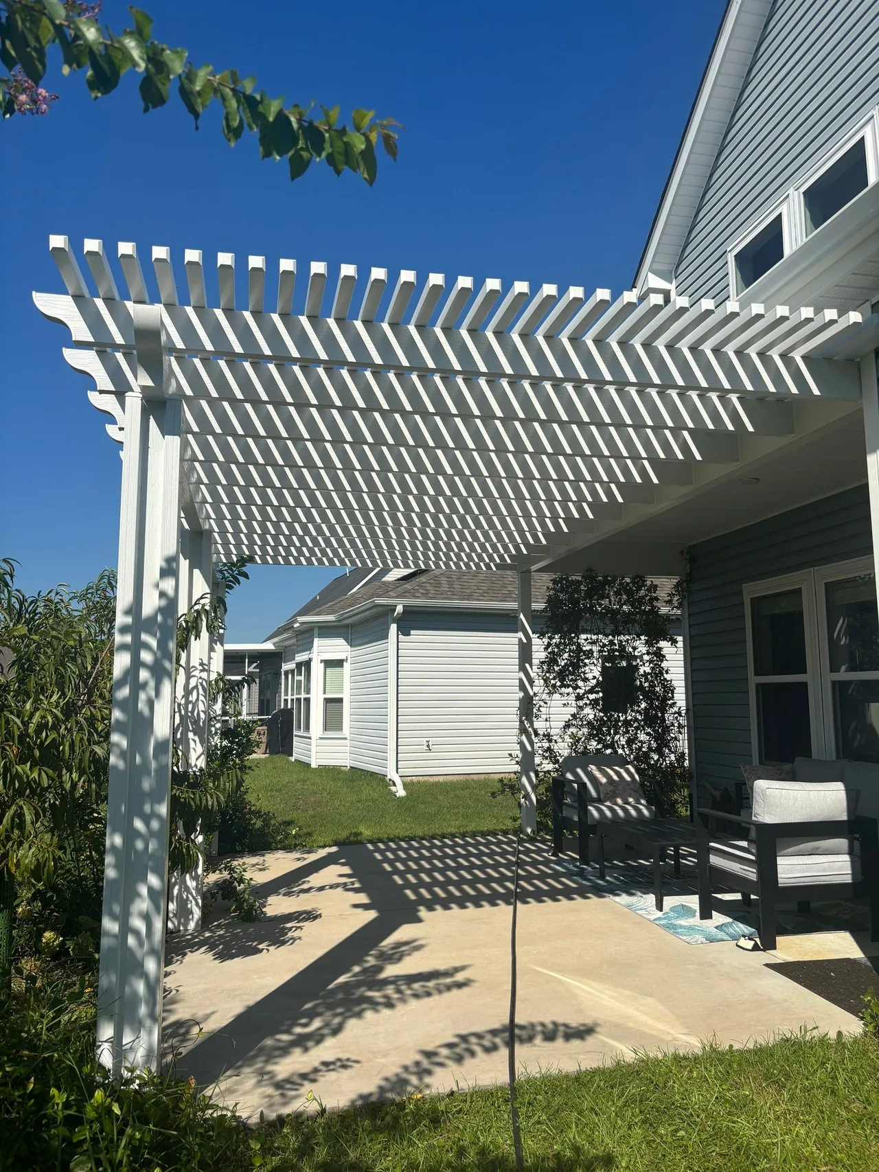 Completed white attached pergola over a Surfside Beach patio beside an existing covered sitting area
