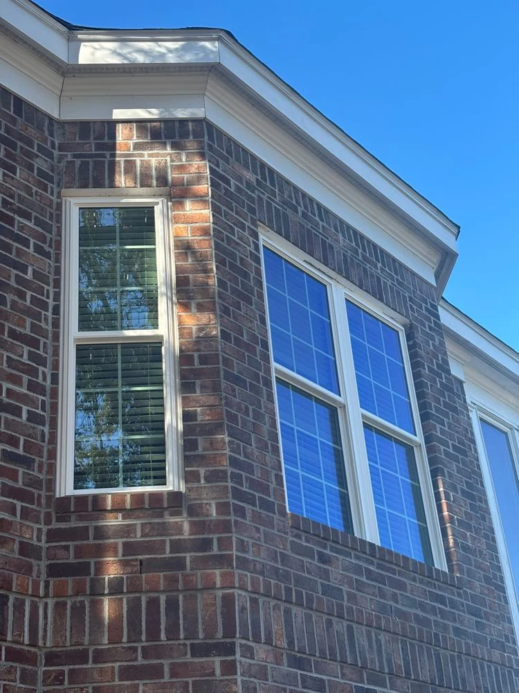 White-framed grid windows set into an angled brick wall at a Pawleys Island home