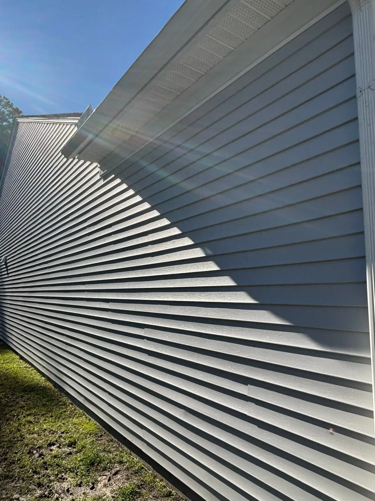 Finished gray vinyl siding beneath white eaves on a Carolina Forest home.