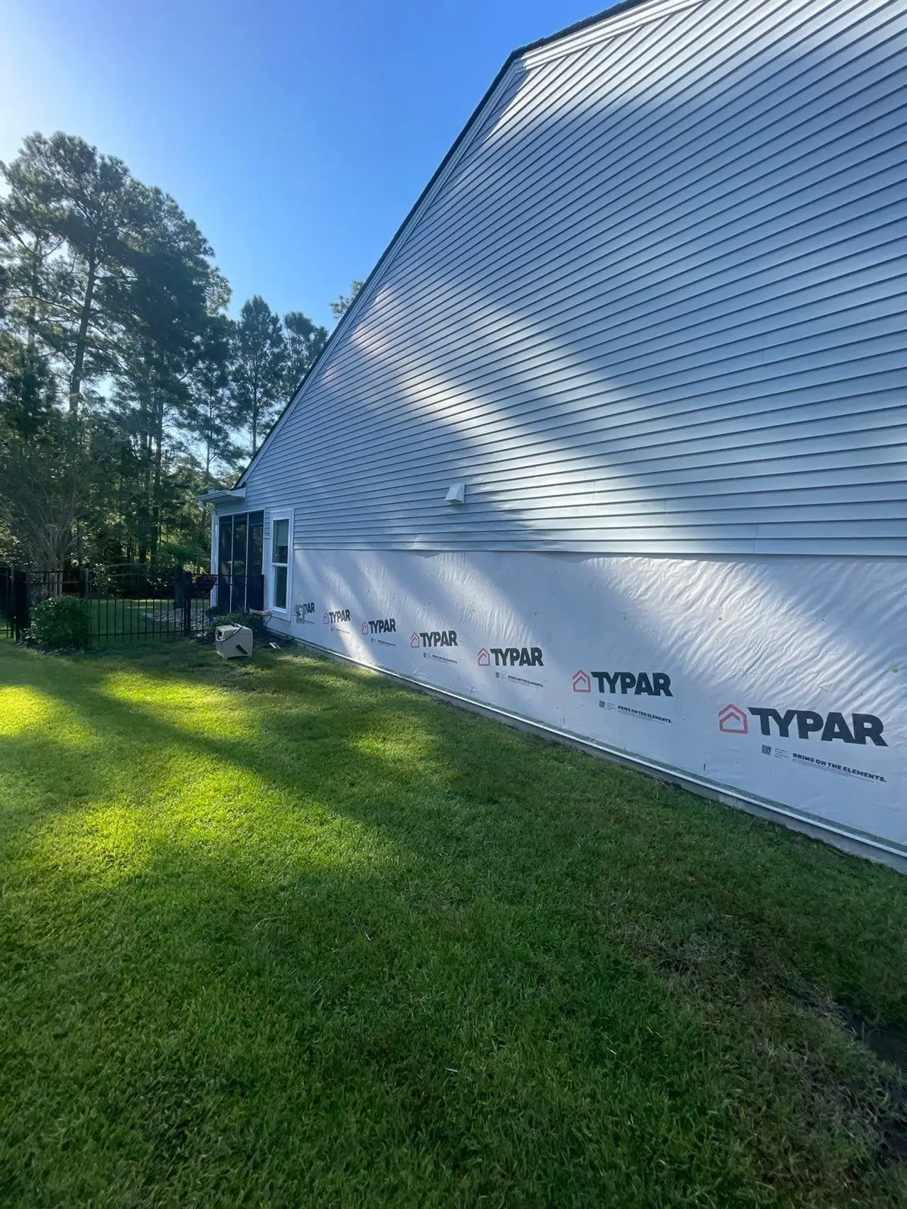 Carolina Forest siding work in progress with a strip of house wrap exposed near the bottom of the wall.