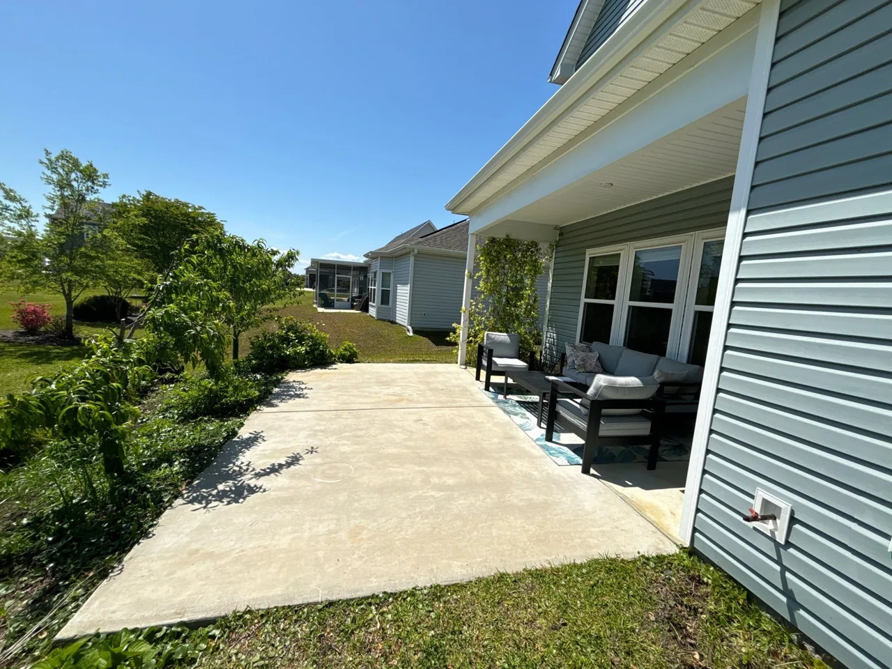 Surfside Beach concrete patio beside an existing covered sitting area before the pergola addition