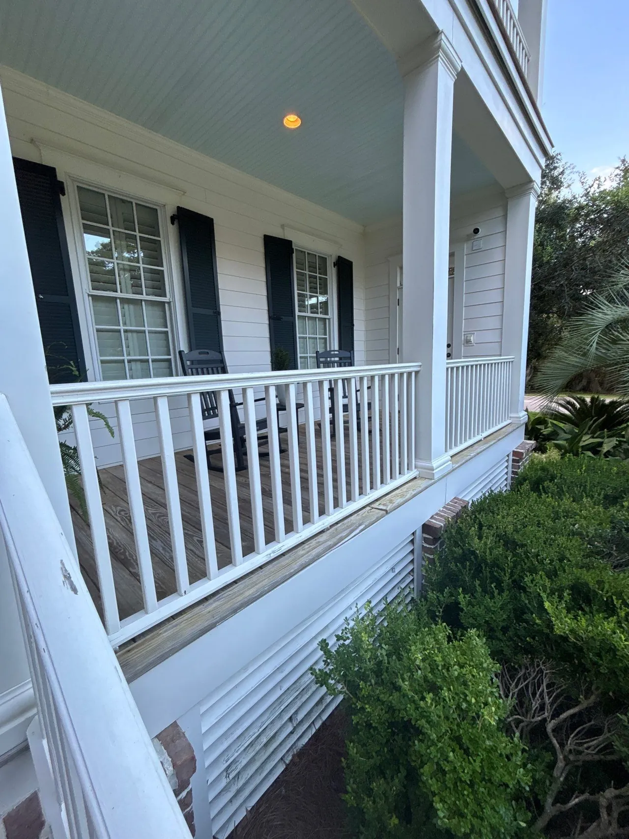 Existing white wood railings around a covered porch in Pawleys Island