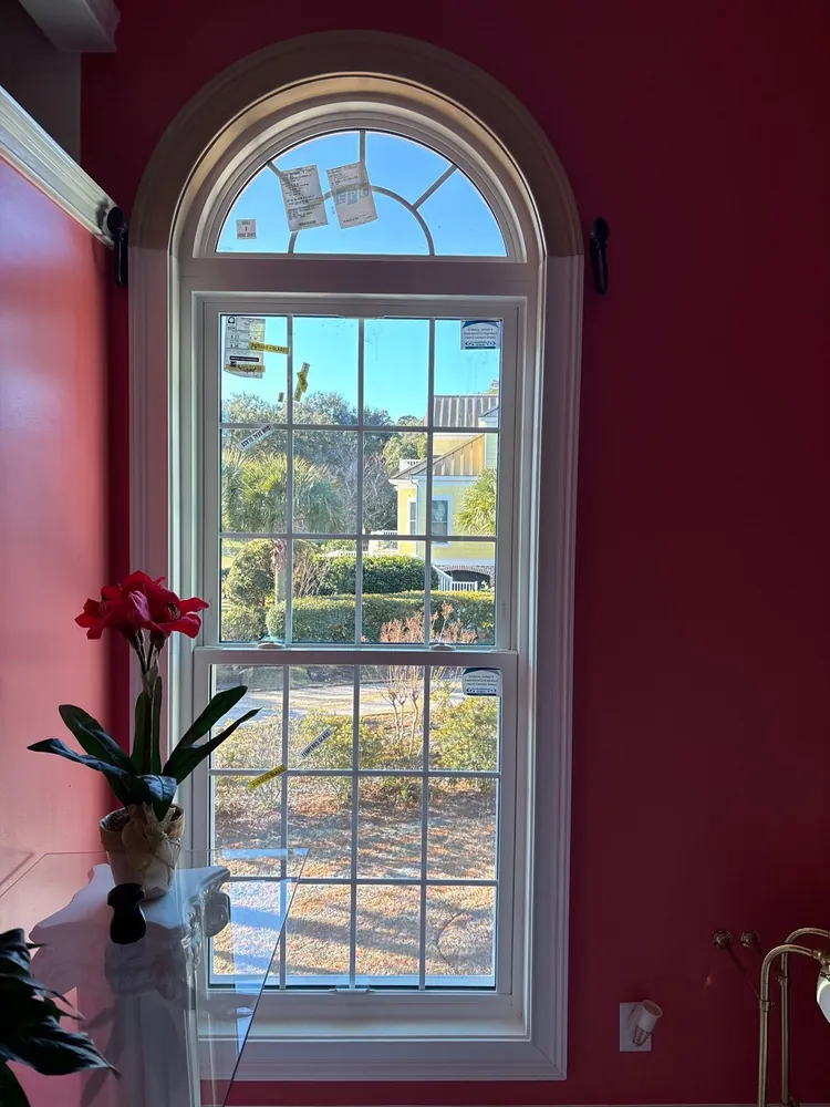 White-framed window and arched upper glass in a red-painted room during the Pawleys Island installation