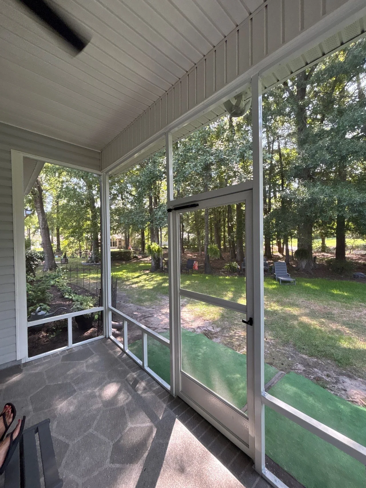 Interior view of the screen door, closer and adjoining screened wall with lower divided panels.