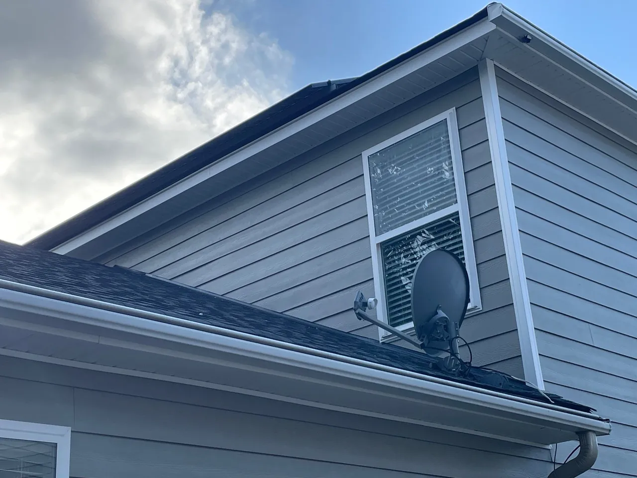 Shingle-pattern gable with white window surround and horizontal band during the Summerville siding project