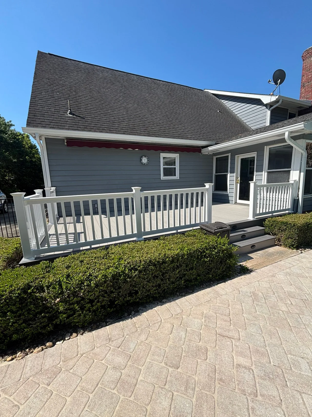 Completed Conway deck with gray Boardwalk decking, white railings and steps.
