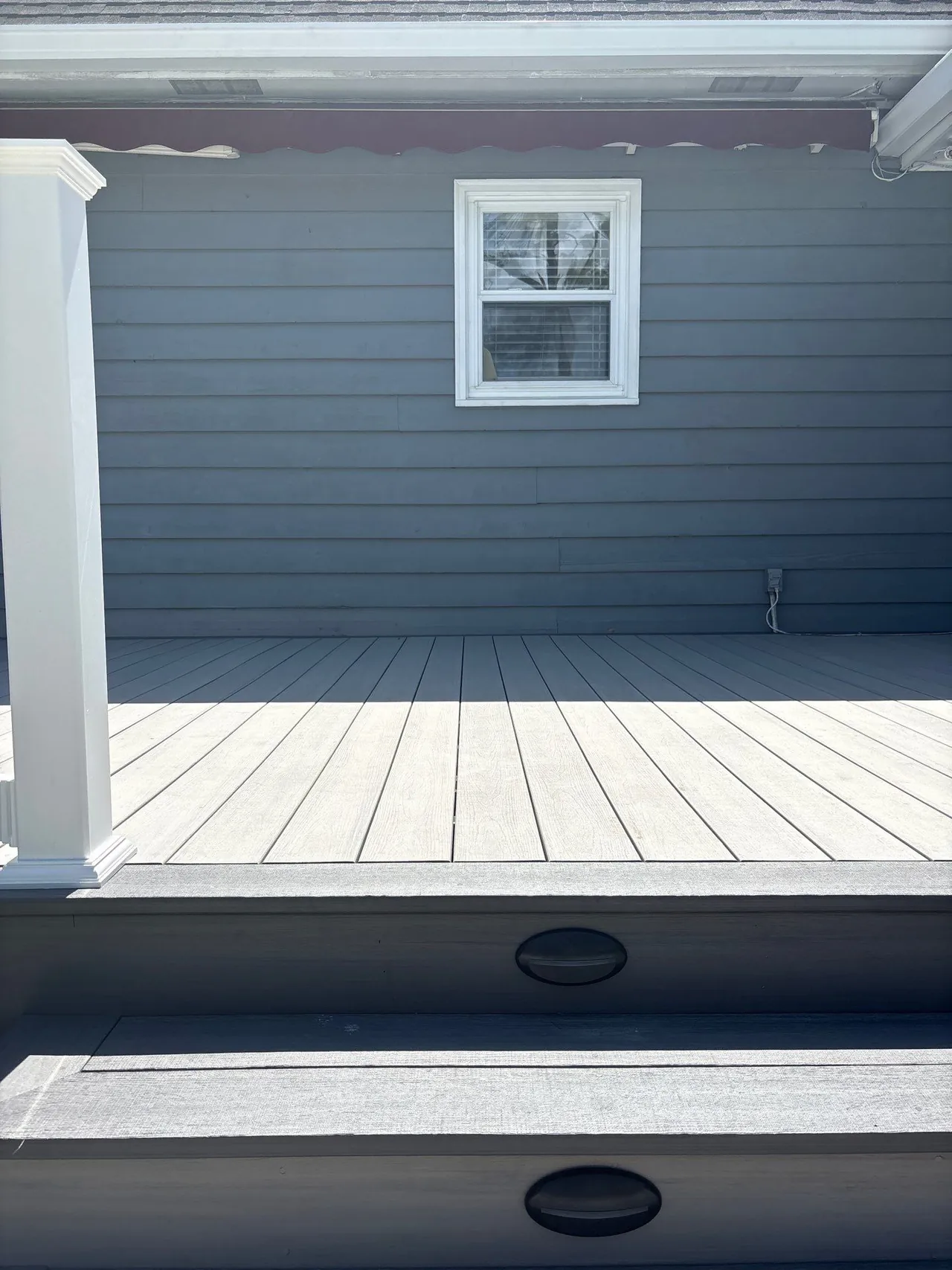 Finished gray deck steps with white railing posts at the Conway home.