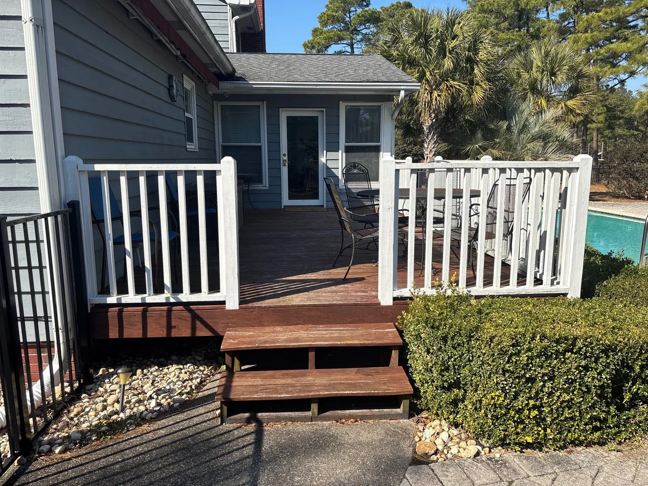 Original wood deck and steps with white railings at the same Conway home.