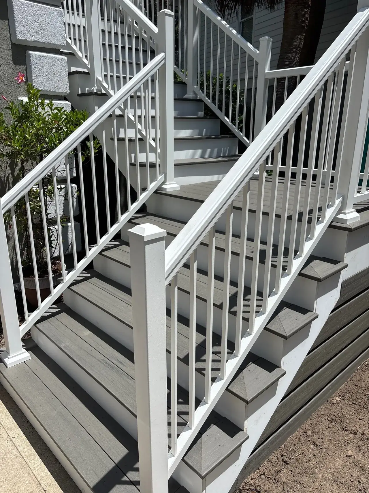 Close view of composite stair treads, white risers and white vertical railing balusters