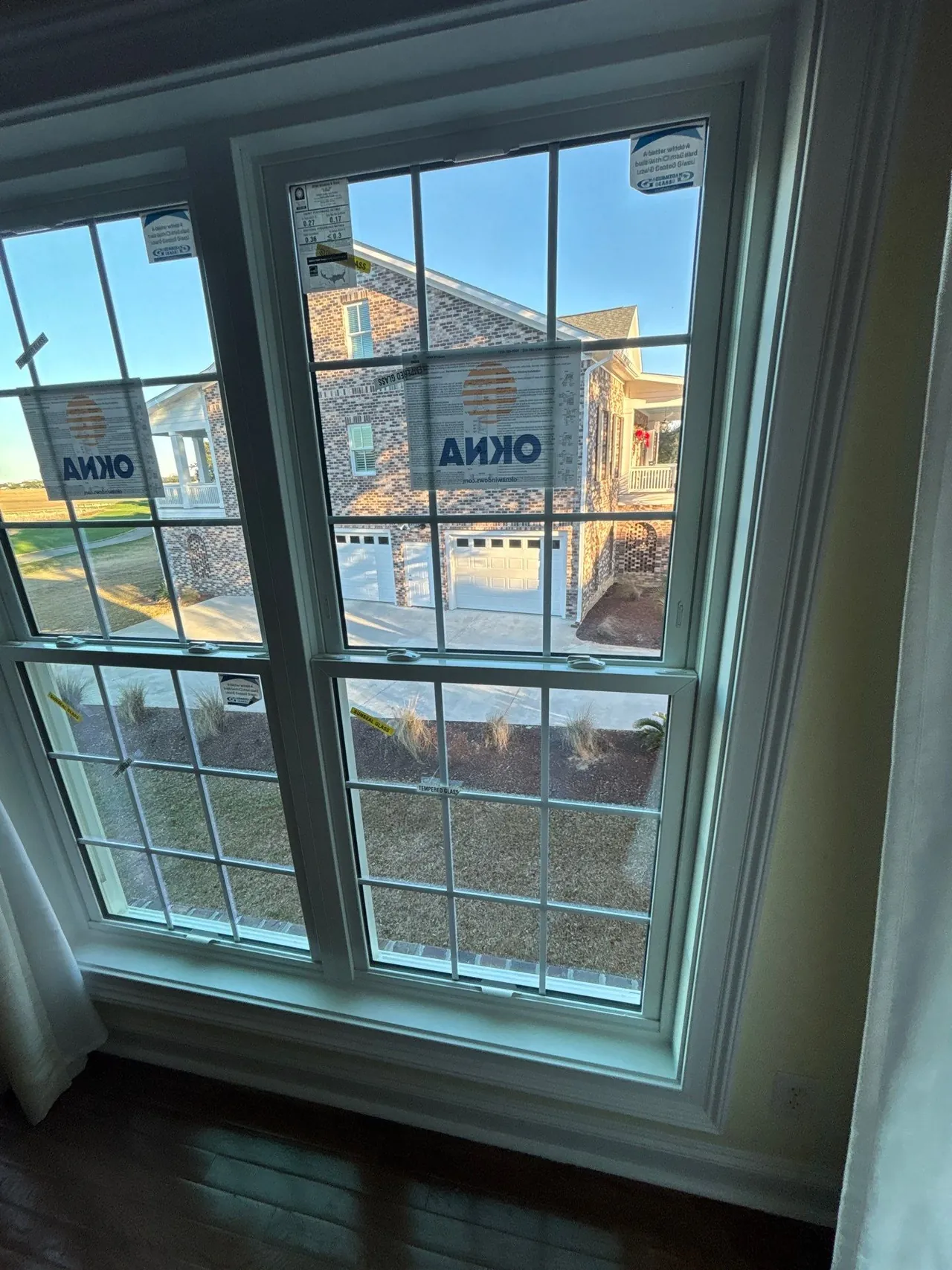 Interior view through a white gridded window with temporary labels during the Pawleys Island installation