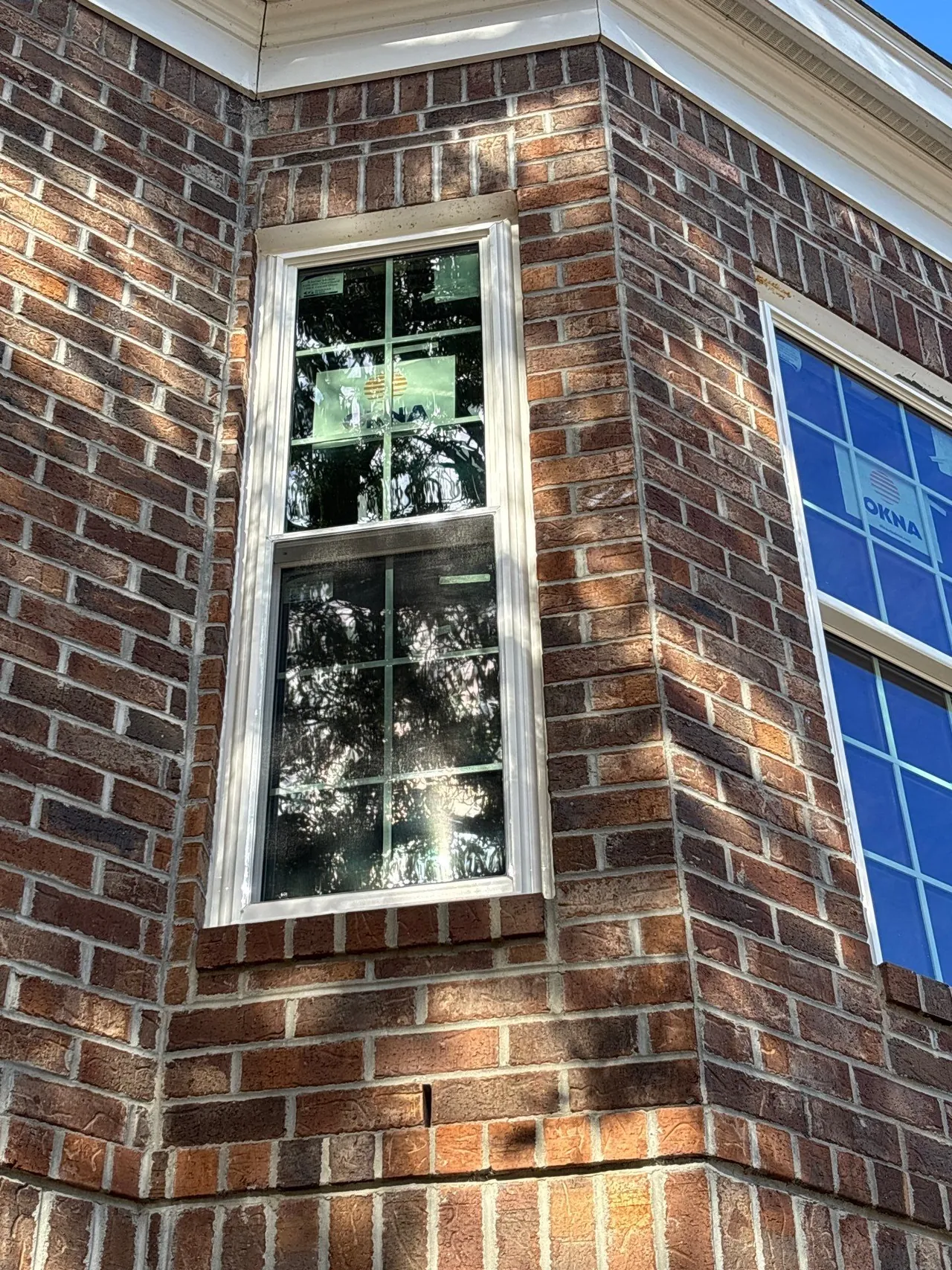 Two adjacent white windows with grid patterns in the brick exterior during the Pawleys Island project